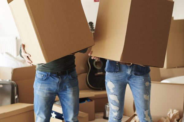 Couple faces behind cardboard boxes